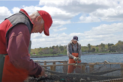Two men working on fishing net.