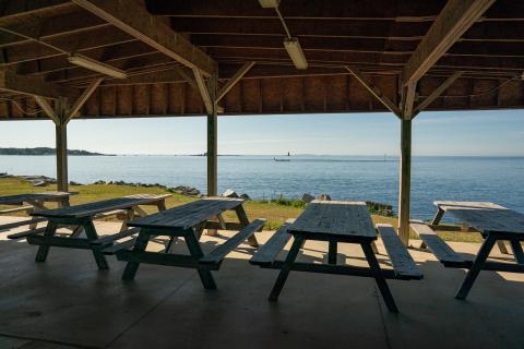 Picnic tables under the pavilion look out over the ocean