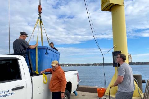 CSSS team members safely unload a tank full of fish to be brought out to the AquaFort platform.