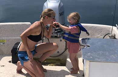 Photo of mother holding daughter's hand on boat.