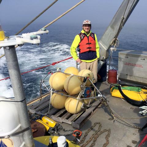 Photo of student on boat surrounded by equipment. 