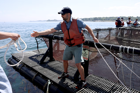 Photo of a man in a life vest standing on a floating aquafort.