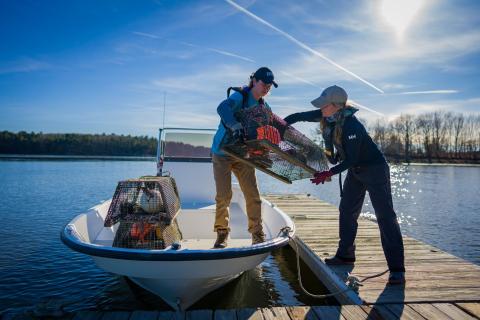 Students unload oyster cages off of boat