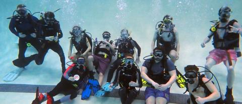 Group photo of diving students in the pool with gear. 