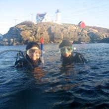 divers in front of lighthouse