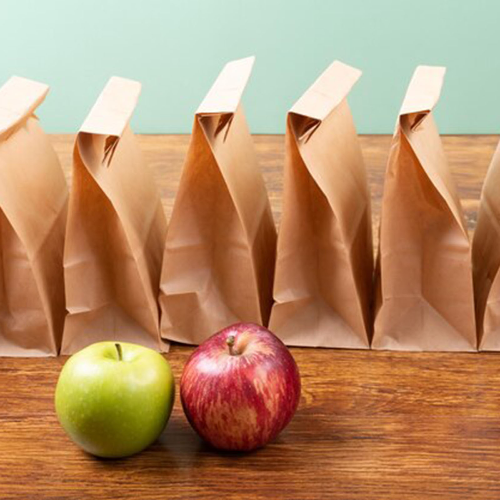  IGhigh-angle-view-apples-with-paper-lunch-bags-arranged-table-against-green-background_13339-326154.jpg